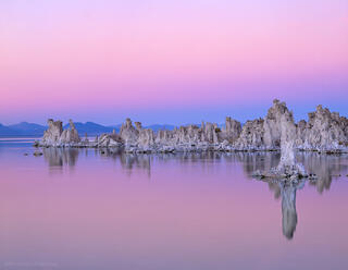 Tufa towers divide the eastern Sierra  pink sunset sky from Mono lake in Lee Vining, California.