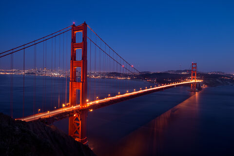 Nighttime approaches and illuminates the famous Golden Gates Bridge, connecting San Francisco to Marin Headlands, California.