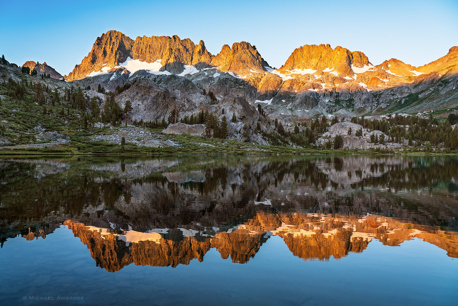 The Minarets reflect in Ediza lake as a perfect backcountry view in the Ansel Adams Wilderness and Mammoth Lakes Sierra.