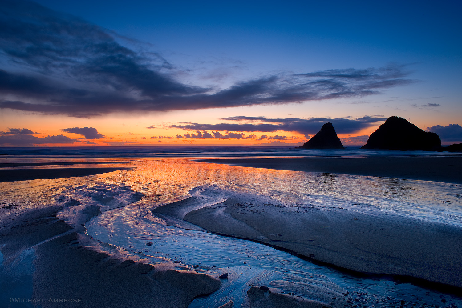Dramatic sunset colors divide the ocean from the sky at Heceta Beach, Oregon.