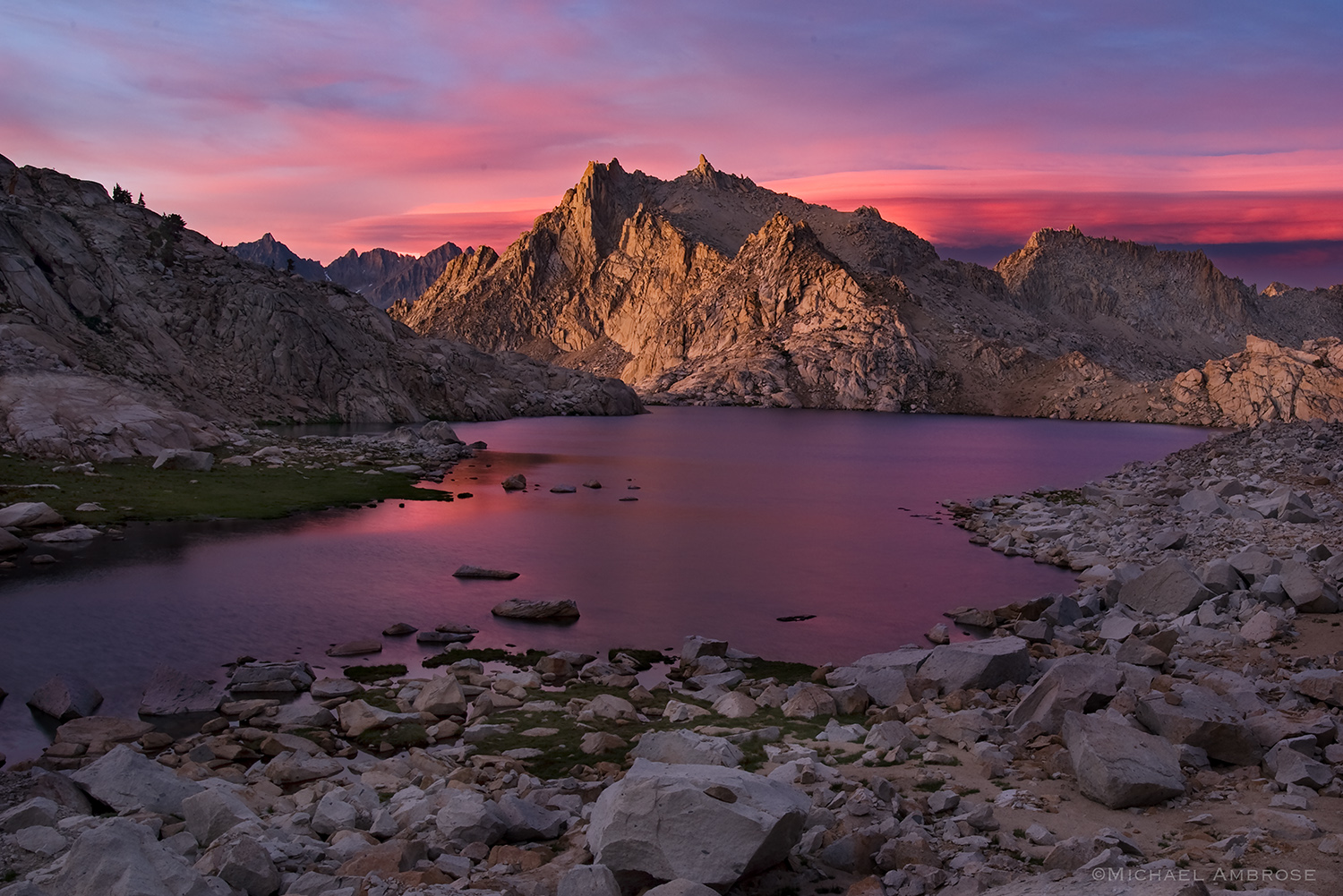 Pink sunset light illuminates Colombine Lake and the Sierra Nevada range in Sequoia National Park, California.