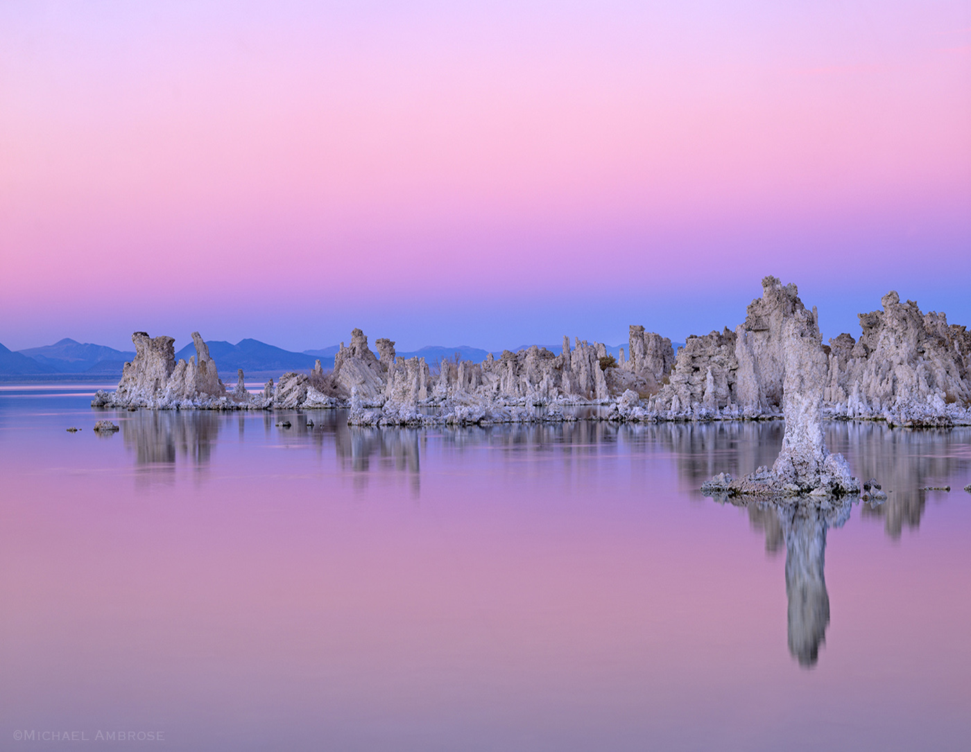 Tufa towers divide the eastern Sierra  pink sunset sky from Mono lake in Lee Vining, California.