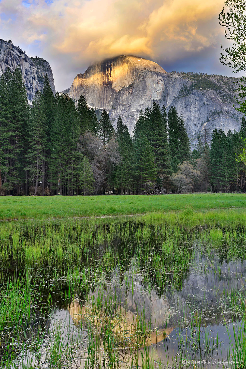 Half dome reflects in the flooded Ahwahnee Meadow as a storm breaks over Yosemite Valley.